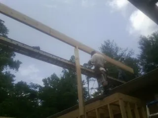 Carpenter setting a ridge beam over a new addition frame — Ice Dam Removal by Roofing Brothers in Kings Mills