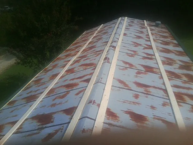 Rusted metal roof panels with new wood purlins before replacement — Storm Damage Roof Repair in Kings Mills by Roofing Brothers