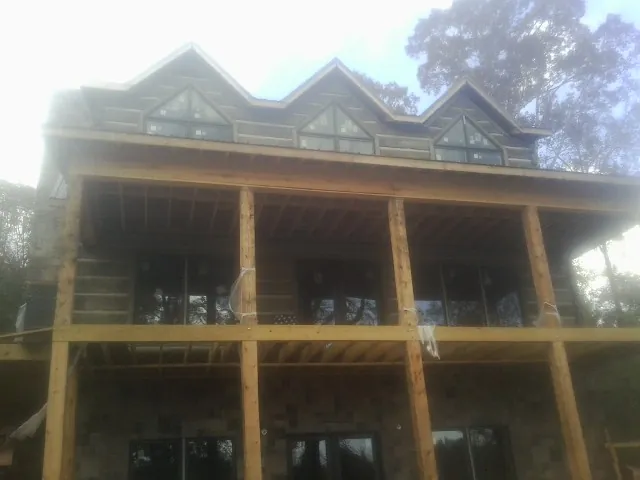 Dormers and porch framing on a large log home under construction — Roof Coating work by our crew in Kings Mills