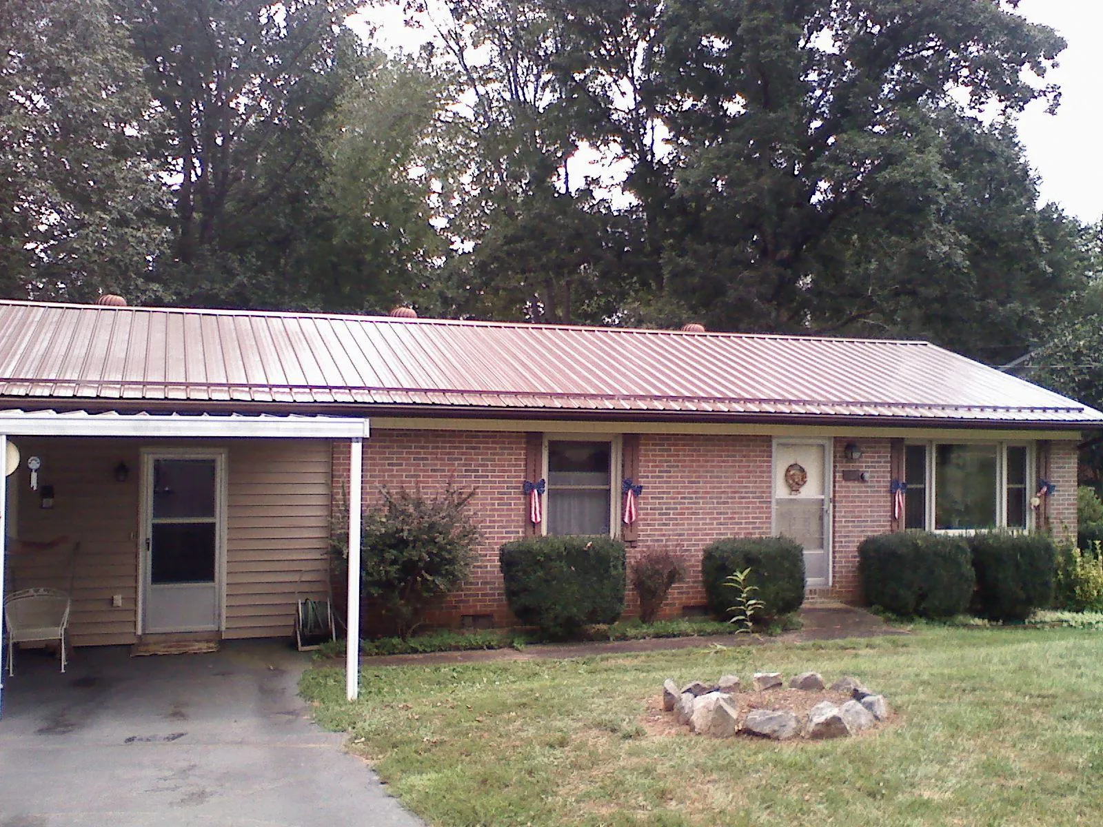 Bronze metal roof and carport on a brick ranch home — Roof Repair work by our crew in Kings Mills
